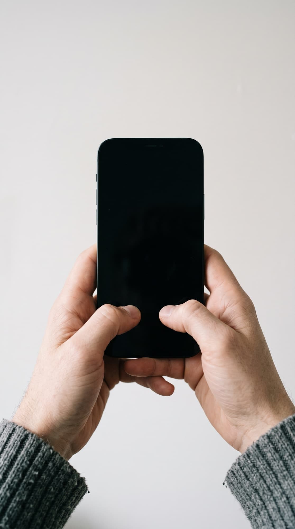 Two hands holding a phone upright, ready to type